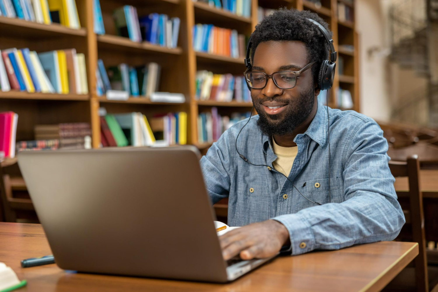 Une personne étudie sur son ordinateur à la bibliothèque